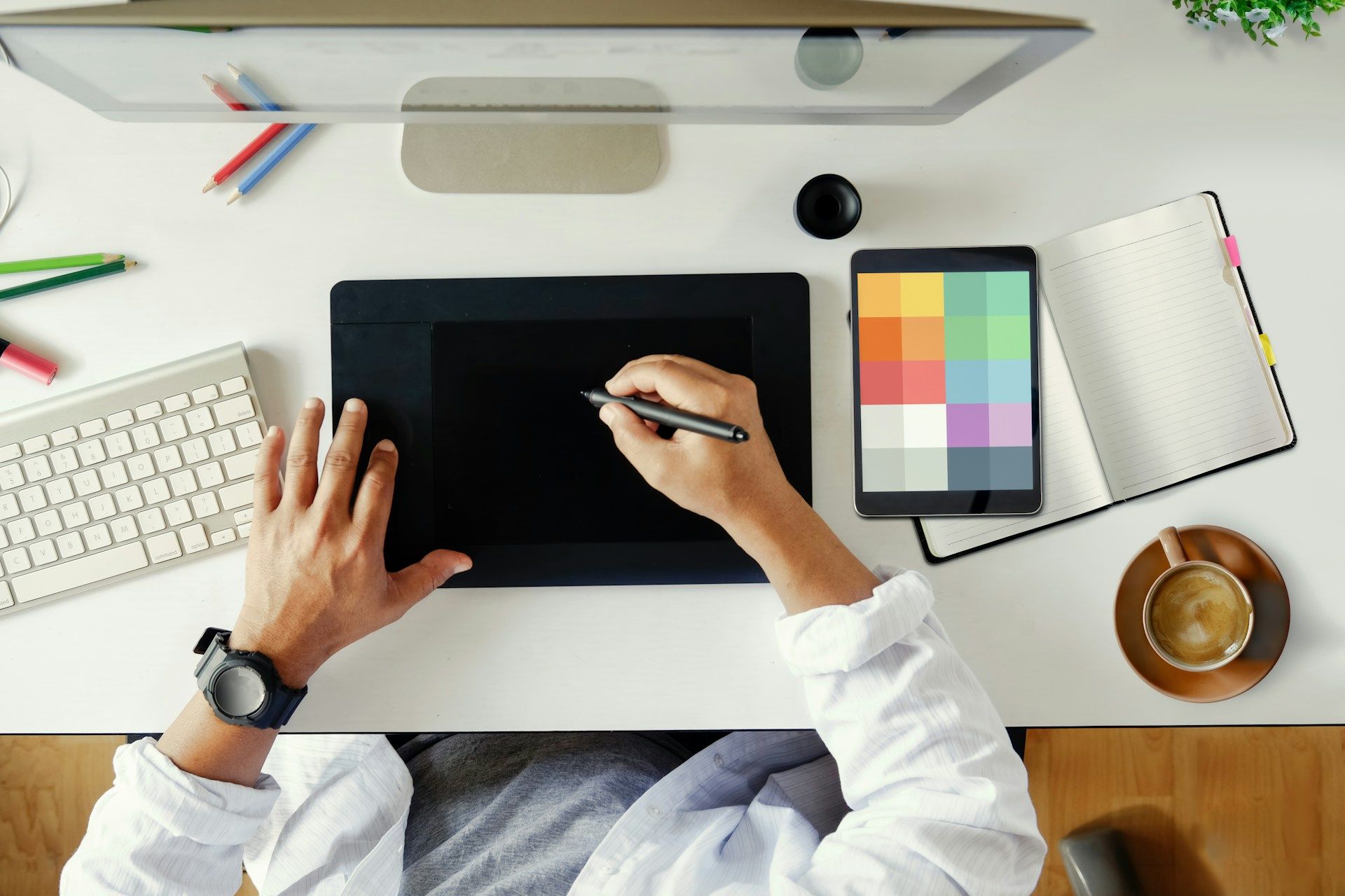 A person is sitting at a desk using a graphic tablet.